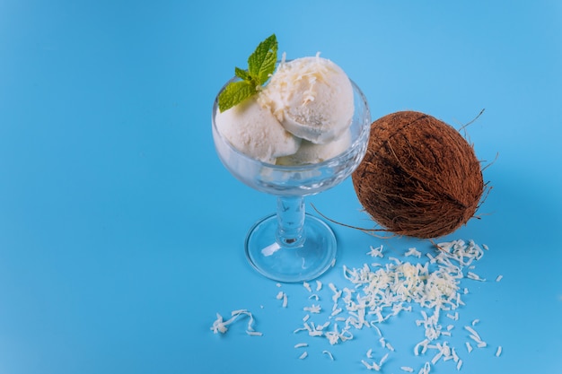 Helado de coco, tres cucharadas en un recipiente de vidrio.