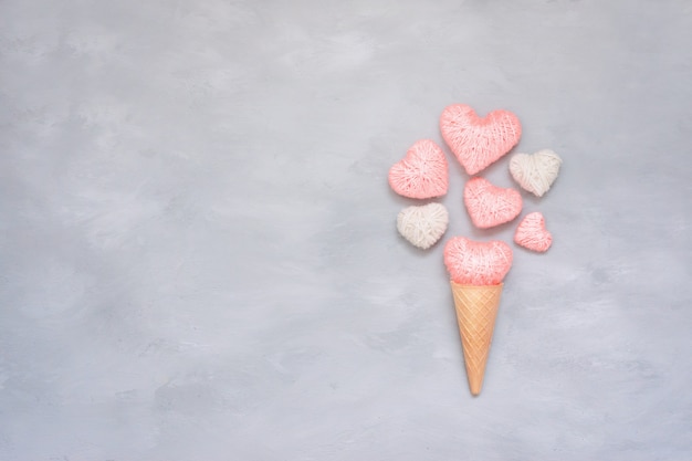 Helado de cono de waffle con hilo rosa y corazón blanco.