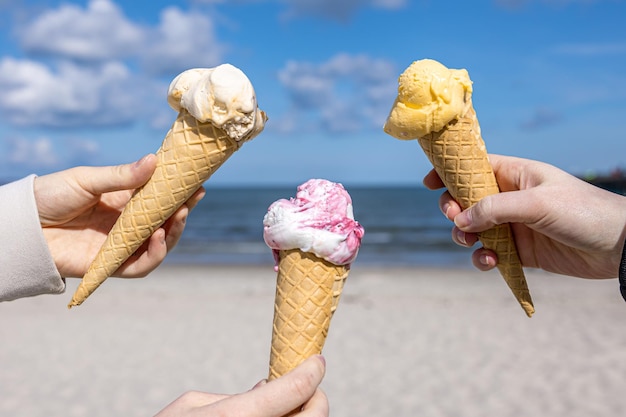 Helado en conos de gofres en manos femeninas en el fondo del mar