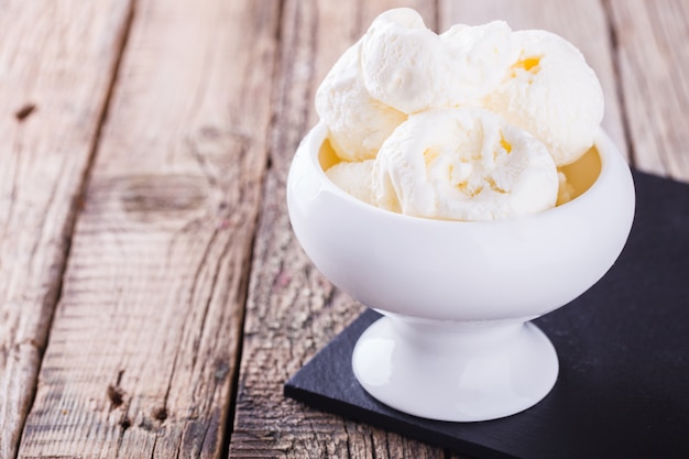 Helado, crema blanca en un tazón de cerámica blanca.