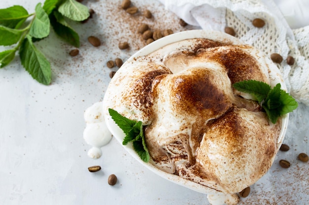 Helado cremoso con menta de chocolate y café en una taza sobre una mesa de cocina de mármol Espacio para copiar