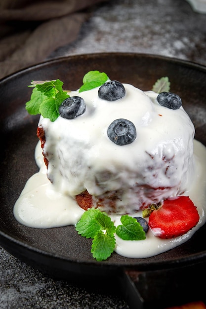 Helado dulce de postre de verano hecho de puré de bayas de azúcar crema y bayas de temporada con crema de queso y azúcar en polvo