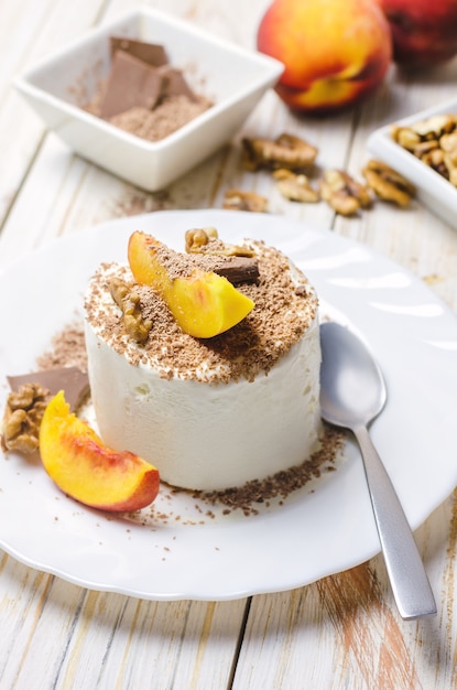 Helado con durazno, chocolate y nueces.