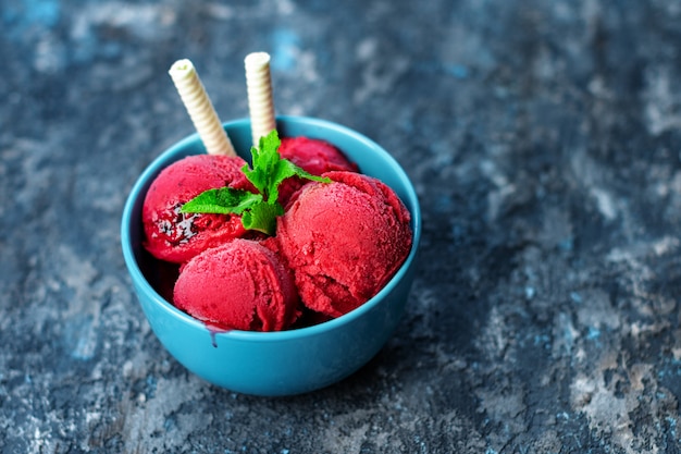 Helado de frambuesa en un tazón sobre la mesa de piedra