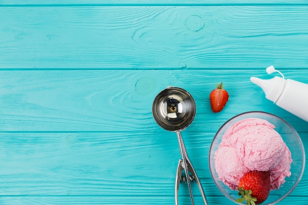 Helado de fresa y cuchara para servir.