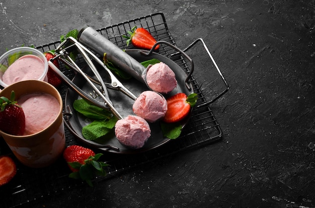 Helado de fresa con menta y fresas Cuchara de helado En una vista superior de fondo de piedra negra