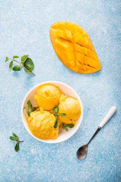 Foto helado de mango, sorbete en un plato sobre un fondo de hormigón, vista superior