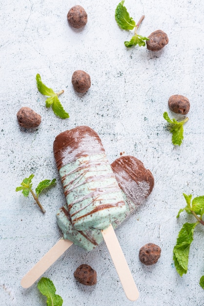 Foto helado de menta con chispas de chocolate, cubierto con una barra de chocolate postre dulce de paletas y paletas. vista superior y espacio de copia.