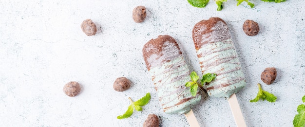 Helado de menta con chispas de chocolate, cubierto con una barra de chocolate Postre dulce de paletas y paletas. Vista superior