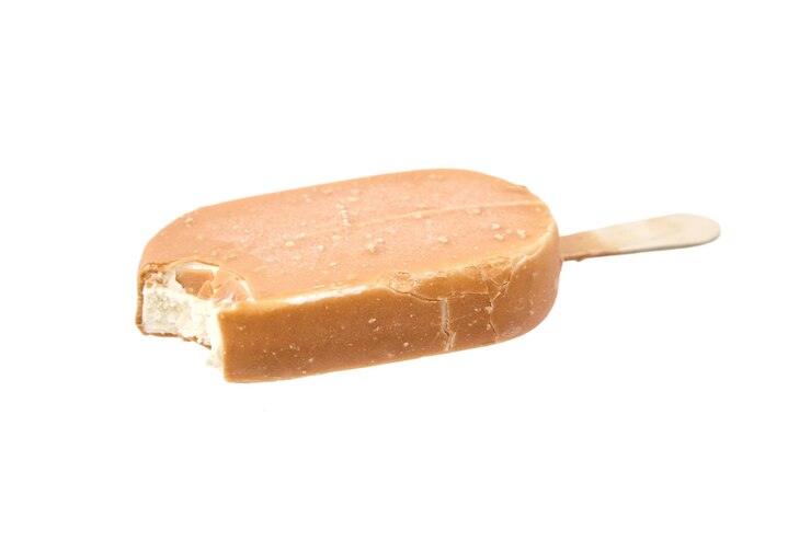 Helado mordido en glaseado de caramelo en un palo de madera aislado en blanco
