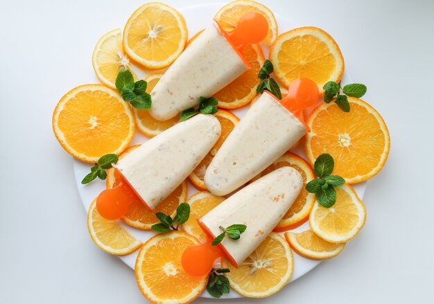 Helado de naranja y rodajas de naranja en un plato