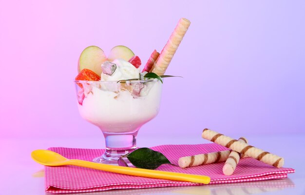 Helado con palitos de oblea en servilleta sobre fondo de color