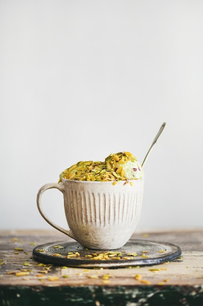 Helado de pistacho en taza con espacio de copia de pistachos