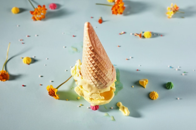 Helado de plátano con cono de galleta sobre fondo azul con flores amarillas.