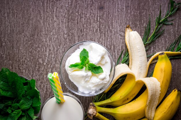 Helado con plátano fresco y menta en mesa de madera