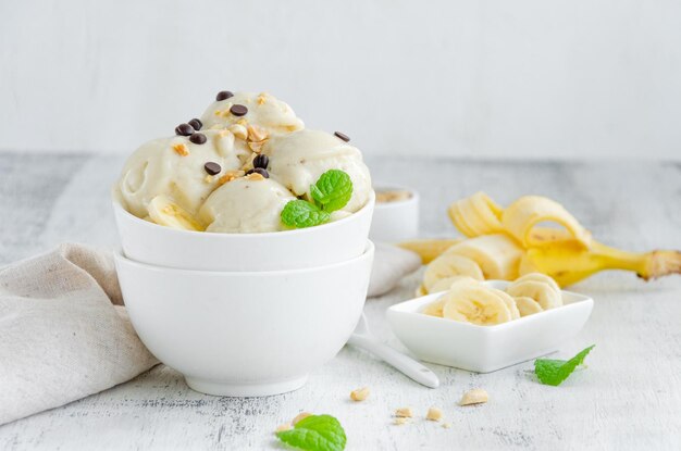 Helado de plátano vegano casero en un bol con cacahuetes y chocolate Postre saludable