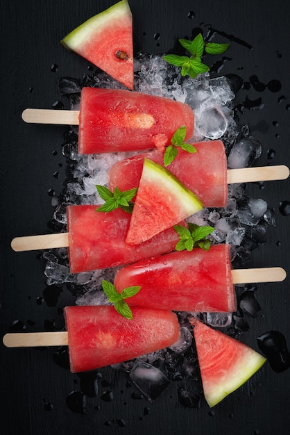 Helado de sandía en mesa de madera negra