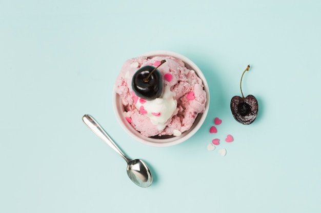 Foto helado en un tazón con cereza cerca de una cuchara