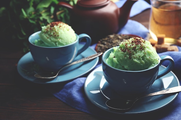 Helado de té verde casero en taza sobre fondo de madera