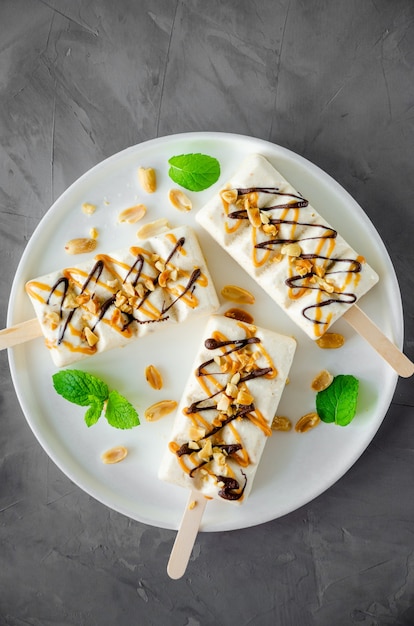 Helado con turrón. caramelo y maní en un palito