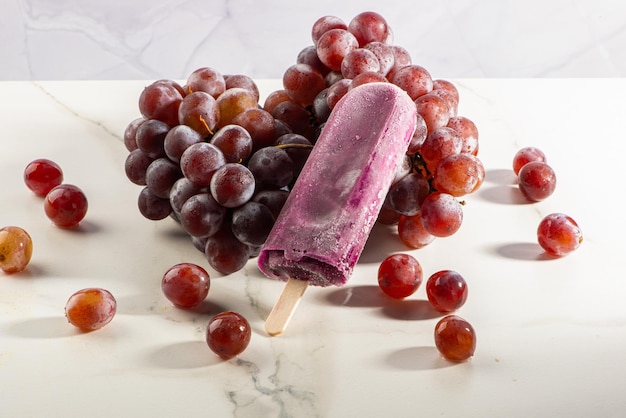 Foto helado de uva en racimos de uvas sobre fondo blanco.