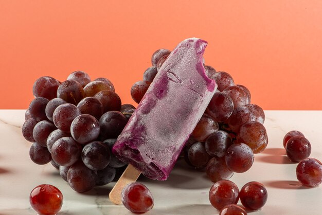 Foto helado de uva en racimos de uvas sobre fondo blanco.