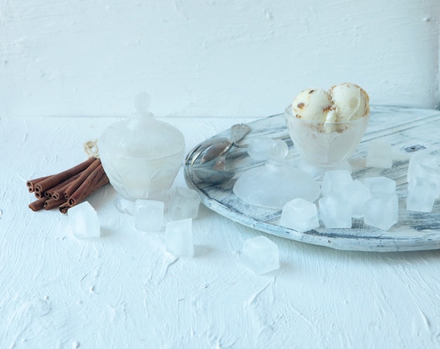 Helado de vainilla blanco ecológico casero con frutos secos y cubitos de hielo y cinamonas grandes