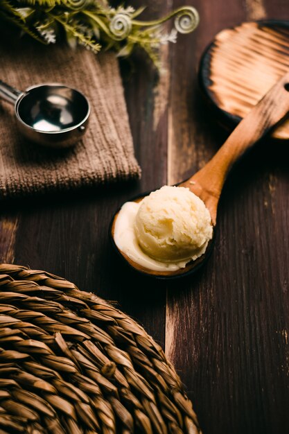 Helado de vainilla casero en mesa de madera con cubiertos vintage