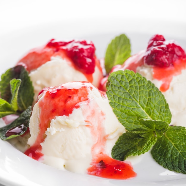 Helado de vainilla con mermelada de fresa y hojas de menta