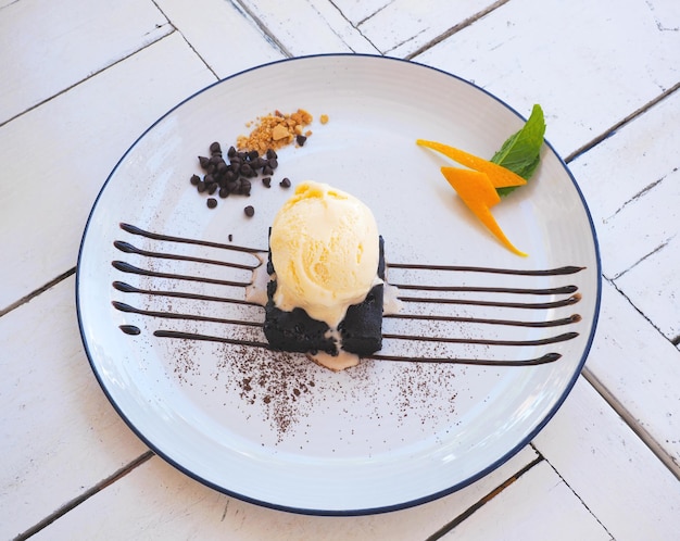 Helado de vainilla y pastel de beownie en un plato blanco