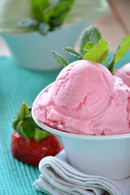 Helados de varios sabores, acompañados de menta, mandarina y fresas.