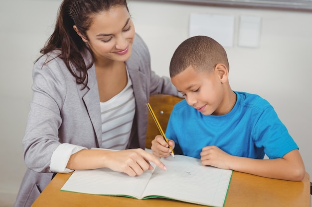 Helfender Schüler des hübschen Lehrers an seinem Schreibtisch