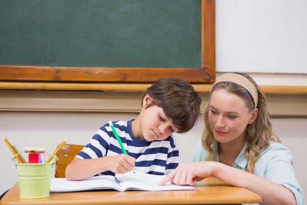 Helfender Schüler des Lehrers im Klassenzimmer