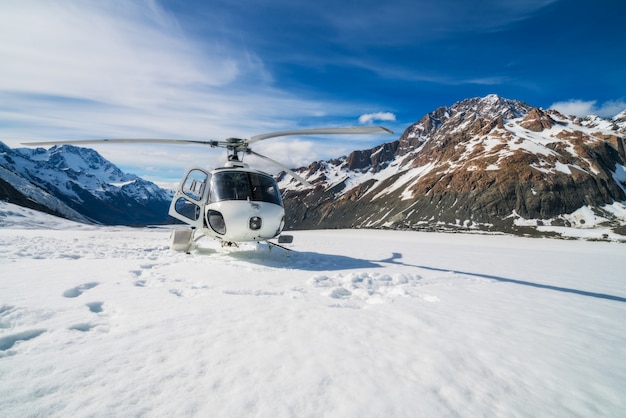 Helicóptero aterrizando en una montaña nevada