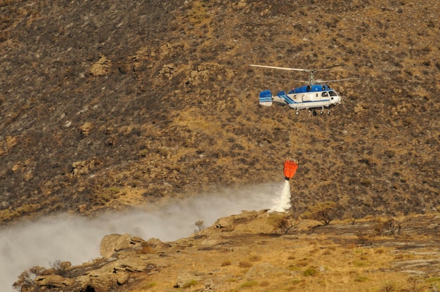 Helicóptero contra incendios realizando una descarga de agua