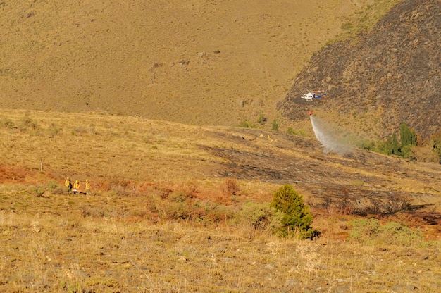 Helicóptero contra incendios realizando una descarga de agua