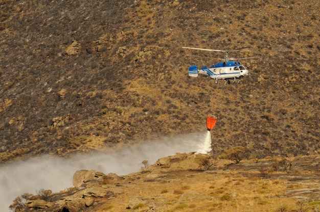 Helicóptero contra incêndios realizando uma descarga de água