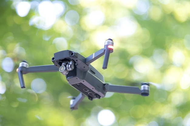 Helicóptero drone con hélices borrosas y cámara de video volando en el aire