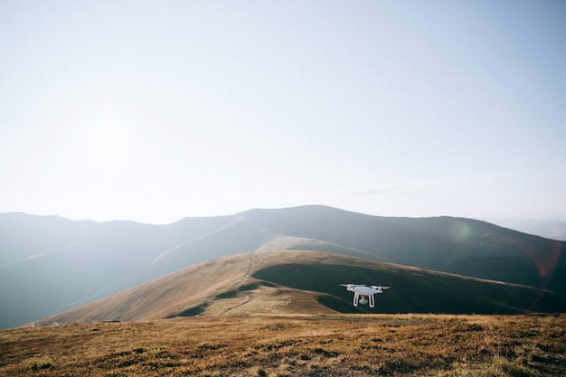 Helicóptero Drone volando con cámara digital en las montañas