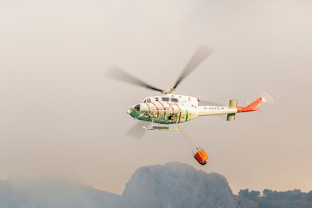 Foto helicóptero de extinción de incendios recogiendo agua del embalse de guadalest