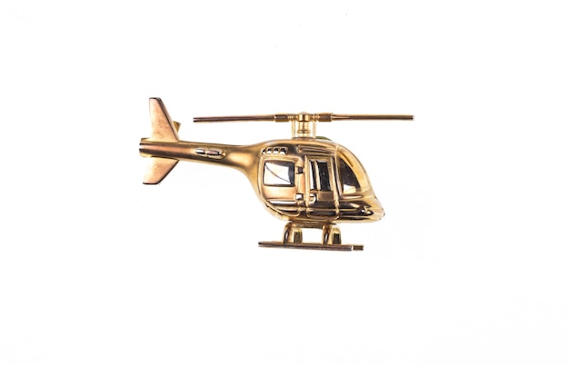 Helicóptero de juguete dorado aislado sobre fondo blanco.