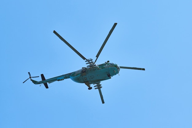 Helicóptero de la marina volando contra el fondo de cielo azul brillante, copie el espacio. Un helicóptero de guerra antisubmarina militar que demuestra la búsqueda submarina, vista inferior