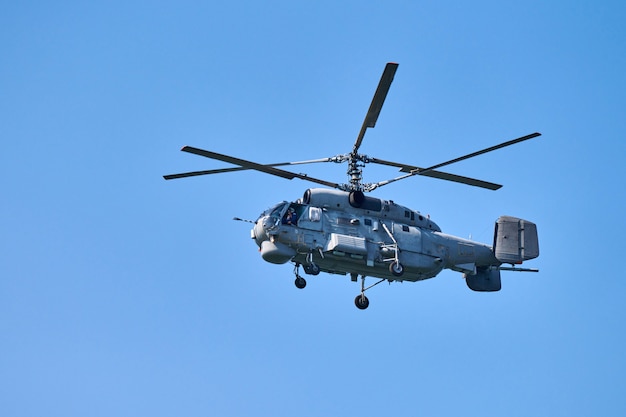 Helicóptero de la marina volando contra el fondo del cielo azul claro, copie el espacio. Un avión de ala giratoria volando mientras realiza demostraciones, vista lateral