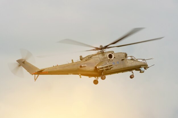 Helicóptero militar com armas no céu.