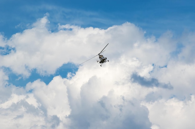 Helicóptero militar está volando a la cámara en el cielo azul con nubes