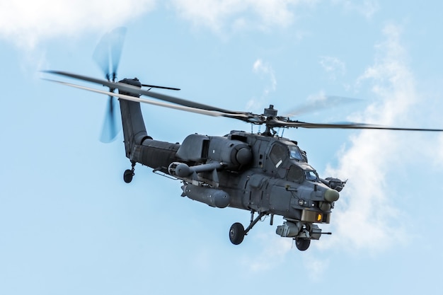 Helicóptero militar no céu em uma missão de combate com armas.