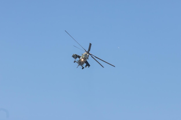 Un helicóptero militar verde que volaba hacia el cielo azul claro de la cámara