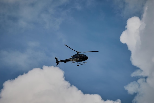 Helicóptero volando en el cielo azul con sol