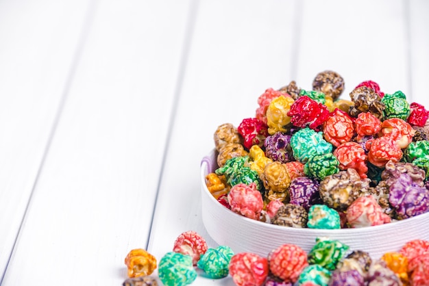 Hell gefärbtes kandiertes Popcorn, weiße Oberfläche