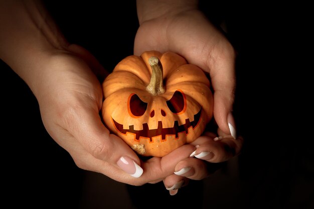 Foto hellaween-maske auf einem kürbis in den händen